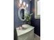 Stylish powder room boasts blue mosaic tile, a vessel sink, and a decorative mirror at 460 Canterwood Dr, Mulberry, FL 33860