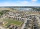Aerial view of a community showcasing a lake, modern homes, and scenic surroundings at 4886 St James Ln, Winter Haven, FL 33881