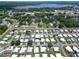 Aerial view of a sprawling mobile home community showcasing lush greenery and a serene lake at 5015 Fox Cliff Dr, Lakeland, FL 33810