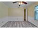Bright bedroom with wood-look floors, ceiling fan, and closet access at 5015 Fox Cliff Dr, Lakeland, FL 33810