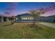 Charming single-story home featuring blue siding, a carport, and mature landscaping against a colorful sky at 5015 Fox Cliff Dr, Lakeland, FL 33810