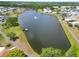 Scenic aerial view of a lake with walking paths and a fountain, enhancing the community's appeal at 5015 Fox Cliff Dr, Lakeland, FL 33810