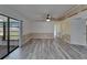 Open-concept living room with wood-look flooring, fan, and access to enclosed porch at 5015 Fox Cliff Dr, Lakeland, FL 33810