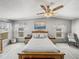 Comfortable bedroom featuring a ceiling fan, two windows, and a cozy rocking chair at 5016 Forest Crest Dr, Lakeland, FL 33810