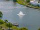 Scenic lake view featuring a water fountain and a wooden dock, offering a tranquil recreational space at 5016 Forest Crest Dr, Lakeland, FL 33810