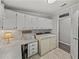 Well-organized laundry room with cabinets, a desk area, and washer/dryer units at 5016 Forest Crest Dr, Lakeland, FL 33810
