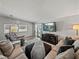 Comfortable living room featuring a plush sectional sofa, large television, and wood-look flooring at 5016 Forest Crest Dr, Lakeland, FL 33810
