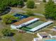Aerial view of community tennis and shuffleboard courts nestled amongst mature trees in a neighborhood setting at 5016 Forest Crest Dr, Lakeland, FL 33810