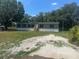 Well-maintained single-story home with gray siding and black shutters in a wooded area at 5248 Rock Dove Trl, Lakeland, FL 33810