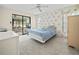 Bedroom with floral wallpaper, sliding glass door access to Florida room, and neutral carpet at 537 Eagle Run, Lakeland, FL 33809