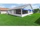 Home exterior with screened patio, blue awning, and lush green lawn at 537 Eagle Run, Lakeland, FL 33809