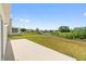 View of the backyard area with a concrete patio and homes across the greenbelt at 5793 Dornich Dr, Auburndale, FL 33823