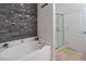 A bathtub with decorative wall and glass door shower is featured in this bathroom at 5793 Dornich Dr, Auburndale, FL 33823