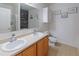 Modern bathroom boasts double sinks with wood cabinets and decorative wall art at 5793 Dornich Dr, Auburndale, FL 33823