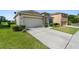 Traditional home with a two-car garage, stone entry, and red window shutters at 5793 Dornich Dr, Auburndale, FL 33823