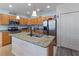 Kitchen featuring a granite island with sink, stainless appliances, and ample cabinet space at 5793 Dornich Dr, Auburndale, FL 33823