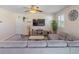 Comfortable living area featuring a large sofa, mounted TV, ceiling fan, and stylish decor, perfect for relaxation at 5793 Dornich Dr, Auburndale, FL 33823