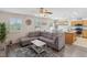 Inviting living room with modern gray sectional sofa, neutral walls, and stylish decor with a combined kitchen area at 5793 Dornich Dr, Auburndale, FL 33823