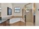 Elegant bathroom featuring a corner tub, a glass shower, and neutral-toned tile work at 6372 English Creek Dr, Lakeland, FL 33811