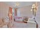 Charming pink and white Bedroom featuring a crib, soft armchair, and stylish decor at 6372 English Creek Dr, Lakeland, FL 33811