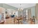 Dining room with hardwood floors, stylish lighting, and adjacent to the living room at 6372 English Creek Dr, Lakeland, FL 33811