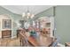 Formal dining area showcasing an elegant chandelier, hardwood floors, and open floor plan to living area at 6372 English Creek Dr, Lakeland, FL 33811