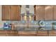 Close up view of kitchen featuring modern cooktop, custom backsplash, sleek range hood, and dark wood cabinetry at 6372 English Creek Dr, Lakeland, FL 33811