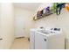 Bright laundry room with tile flooring, shelving, washer, and dryer at 6372 English Creek Dr, Lakeland, FL 33811