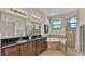 Elegant main bathroom with dual vanities, a soaking tub, and a glass-enclosed shower at 6372 English Creek Dr, Lakeland, FL 33811