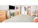 Bedroom offers views of a tv, dresser, open doors and neutral colored walls at 6506 Sedgeford Dr, Lakeland, FL 33811