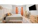 Well-lit bedroom with a bed, stylish decor, wood floors and orange drapes at 6506 Sedgeford Dr, Lakeland, FL 33811