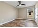 A neutral bedroom with wood-look floors, a window, and a closet at 6625 Thornhill Rd, Winter Haven, FL 33880