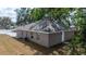 Exterior view of the home featuring a gray paint and mature landscaping at 6625 Thornhill Rd, Winter Haven, FL 33880