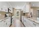 Bright kitchen featuring white cabinetry, stainless steel appliances and stone countertops at 6625 Thornhill Rd, Winter Haven, FL 33880