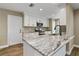 Modern kitchen with stainless appliances, white cabinetry, granite countertops and wood look flooring at 6625 Thornhill Rd, Winter Haven, FL 33880