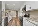 Bright kitchen featuring white cabinetry, stainless steel appliances and stone countertops at 6625 Thornhill Rd, Winter Haven, FL 33880
