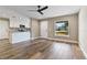 Open-concept living space with hardwood floors, a ceiling fan, a kitchen bar and a light filled window at 6625 Thornhill Rd, Winter Haven, FL 33880