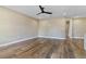 A well lit, spacious, open-concept living room with wood look floors, neutral walls, and modern ceiling fan at 6625 Thornhill Rd, Winter Haven, FL 33880