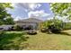 Spacious landscaped backyard featuring lush greenery, a patio area, and a screened pool enclosure at 6626 Royal Forest Dr, Lakeland, FL 33811