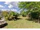 Spacious backyard featuring lush lawn, mature trees, landscaping and a partially visible screened in pool at 6626 Royal Forest Dr, Lakeland, FL 33811