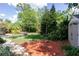 Spacious backyard with lush lawn, mature trees, and a storage shed, perfect for outdoor activities at 6626 Royal Forest Dr, Lakeland, FL 33811