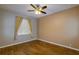 Neutral bedroom featuring wood-look tile floors, ceiling fan, and window with curtains at 6626 Royal Forest Dr, Lakeland, FL 33811