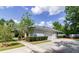 Exterior view of the home featuring a spacious driveway, attached garage, and manicured landscaping at 6626 Royal Forest Dr, Lakeland, FL 33811