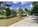 Front yard with lush trees, manicured landscaping, and a view of the house's exterior at 6626 Royal Forest Dr, Lakeland, FL 33811