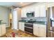 Modern kitchen with stainless steel appliances, granite countertops, white cabinets, and hardwood floors at 6626 Royal Forest Dr, Lakeland, FL 33811