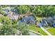 Aerial view of a beautiful home with a screened-in pool and lush landscaping in a serene neighborhood at 6911 Wildberry Ln, Lakeland, FL 33813