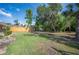 Beautiful backyard featuring lush grass, mature trees, and a charming seating area at 6911 Wildberry Ln, Lakeland, FL 33813