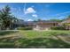 Home's exterior featuring a screened-in pool, well-manicured lawn, and lush landscaping at 6911 Wildberry Ln, Lakeland, FL 33813