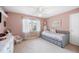 Bright bedroom featuring a ceiling fan, and a comfortable daybed next to a window at 6911 Wildberry Ln, Lakeland, FL 33813