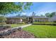 Charming single story home featuring manicured landscaping, green lawn, and a welcoming front entrance at 6911 Wildberry Ln, Lakeland, FL 33813